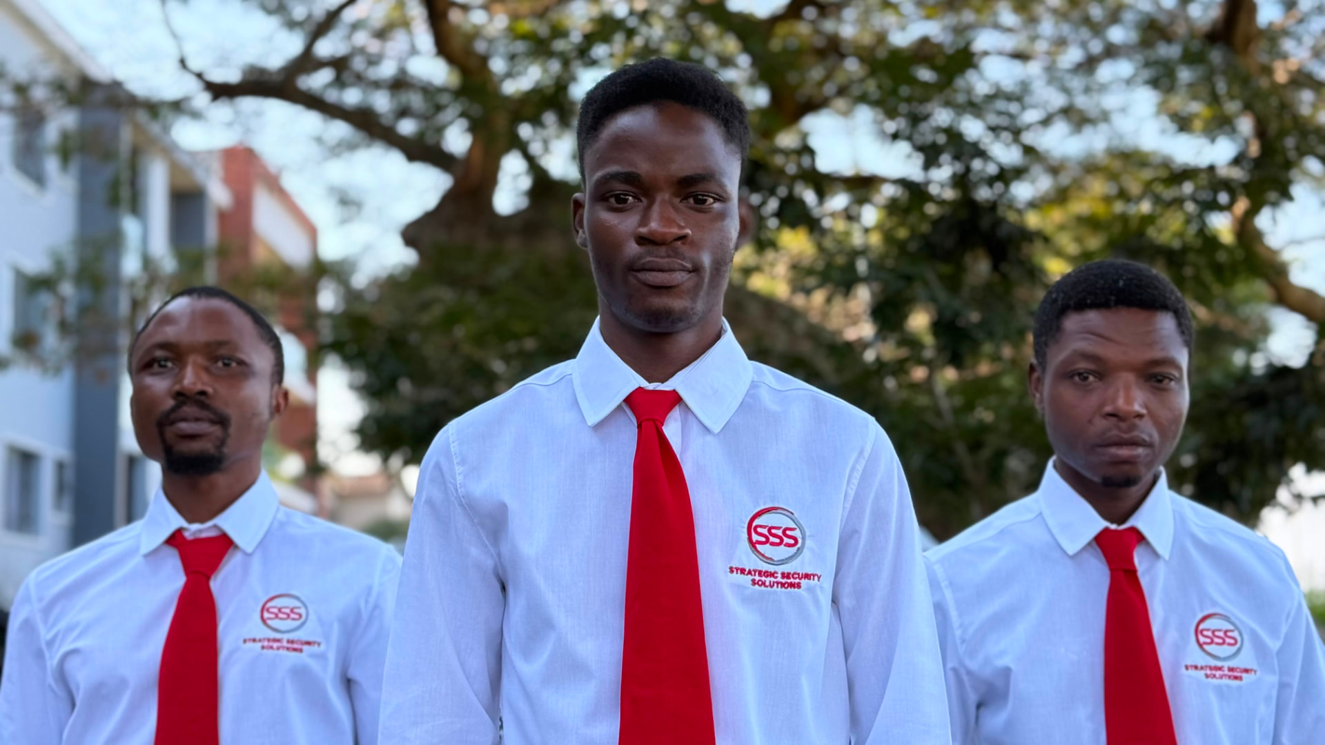 Three Strategic Security Solutions officers in branded uniform on a residential site