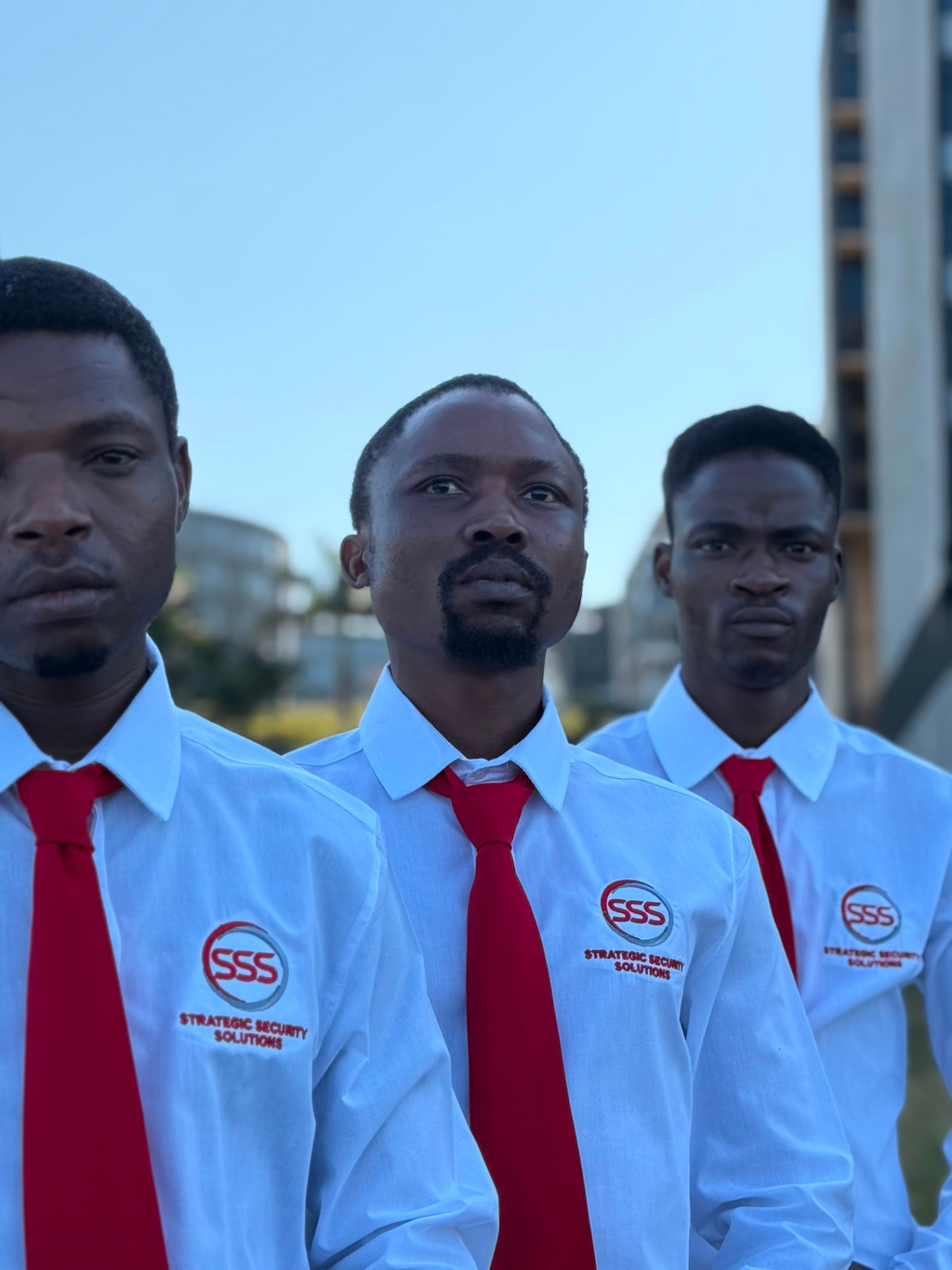 Portrait of SSS security officers wearing the branded shirt and red tie